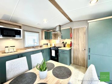 Modern kitchen with green cabinets and wooden countertops.