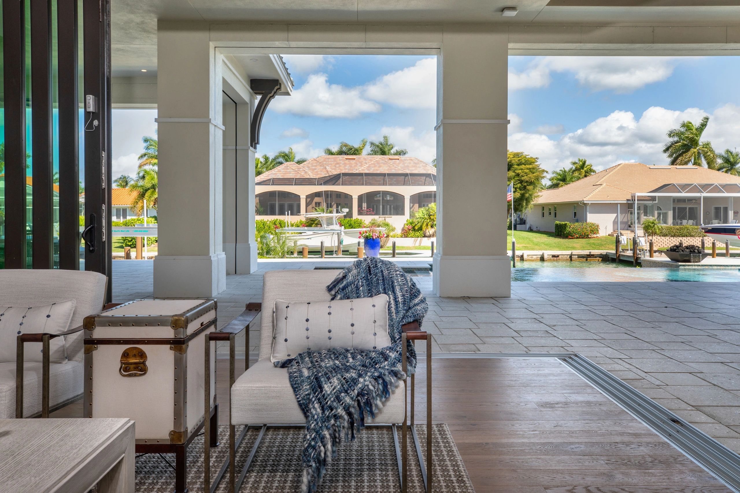 Cozy patio seating with a waterfront view and boats docked nearby.