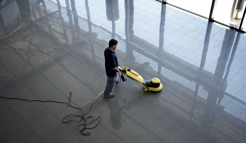 commercial cleaner using buffer cleaner machine on building shiny floors