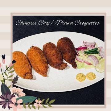 Four crispy prawn croquettes served with onions, green chili, and lemon on a white plate.