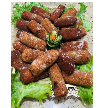Plate of golden-brown croquettes garnished with lettuce and a cucumber rose.