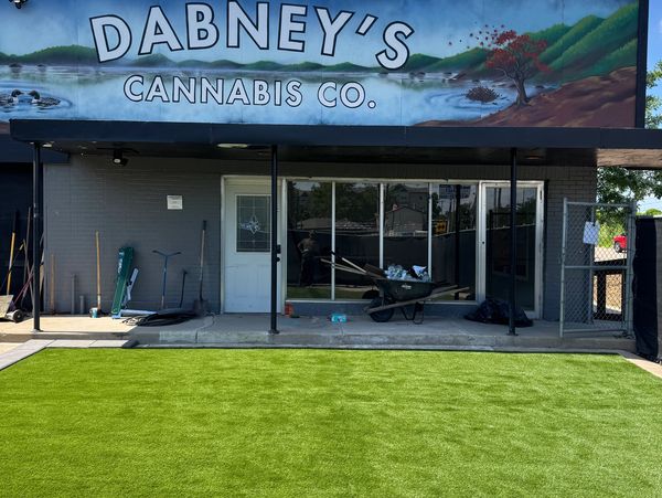 Front of Dabney's Cannabis Co. with garden tools outside.
