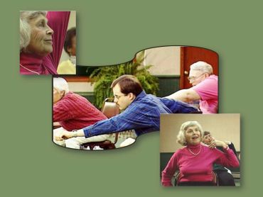 Seniors participating in a seated exercise class, stretching and smiling.