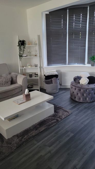 Cozy modern living room with gray sofa and tufted ottoman.