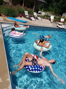 A family relaxing in the pool wearing their lifesavers