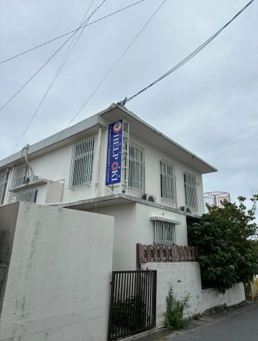 White building with a sign for HELP OKI Volunteer Community Center.