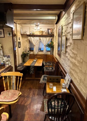 Cozy cafe corner with wooden furniture and floral cushions.