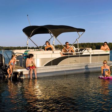 image of several people sitting on pontoon boat in water