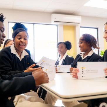 Students engaged in a group discussion holding notebooks.