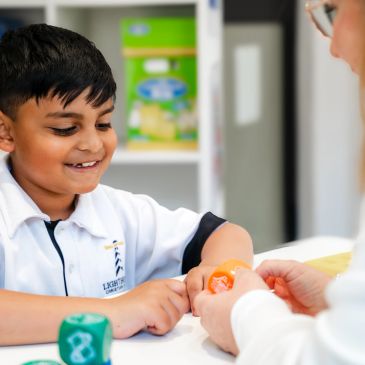 Boy smiling while playing an educational game.