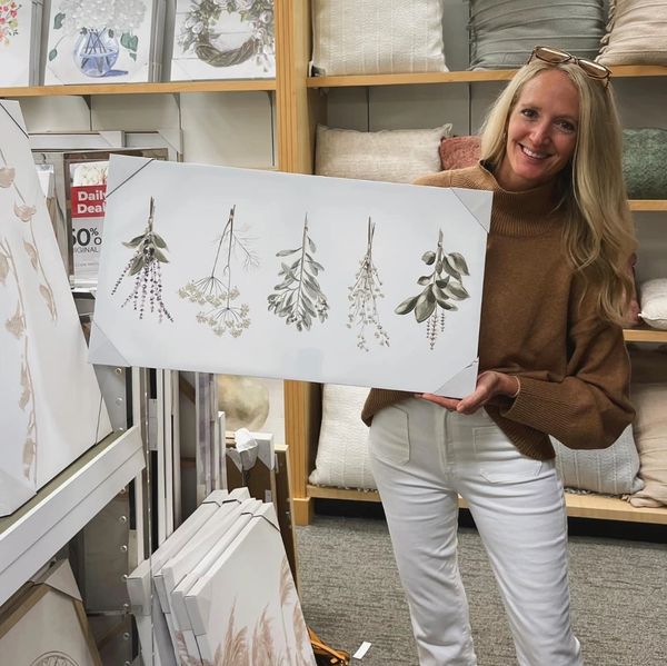 Woman holding botanical print in store.