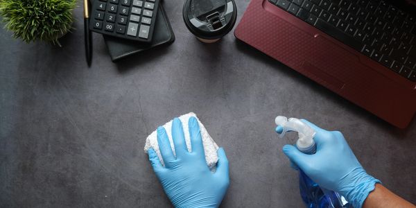 hands cleaning a desk
