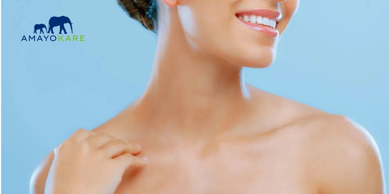 Close-up of a smiling woman with clear skin and a hand on her shoulder.