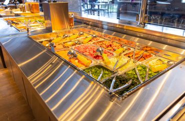 Colorful fresh food items in a restaurant buffet setup.