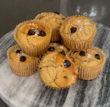 Freshly baked chocolate chip muffins with a sprinkle of sea salt on top.