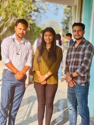 Three young adults posing outdoors in casual and semi-formal attire under sunlight.
