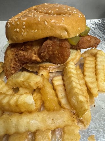 chicken sandwitch hottie sauce and a pickel and fries