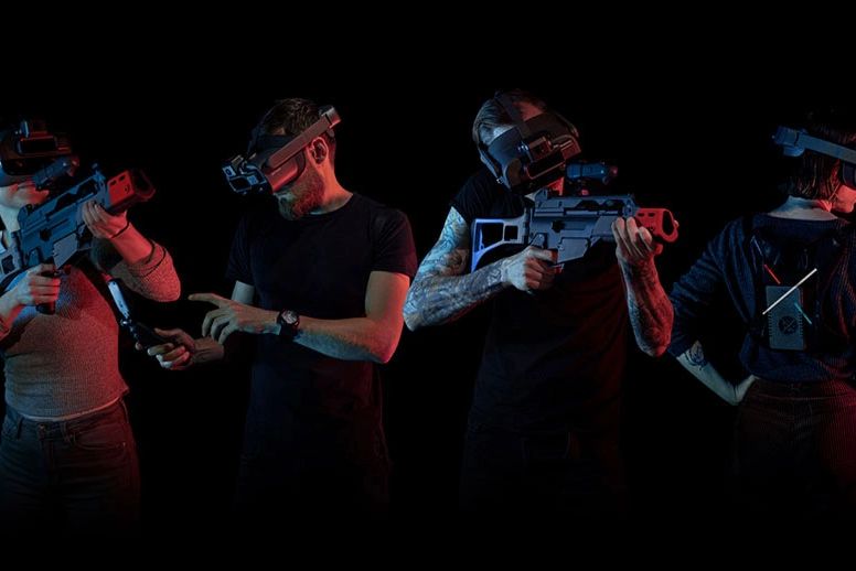 4 people holding toy guns and wearing VR headsets