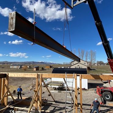 Steel beam hoisted by crane.