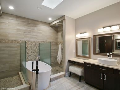 bathroom with bathtub and two mirrors with dark cabinets