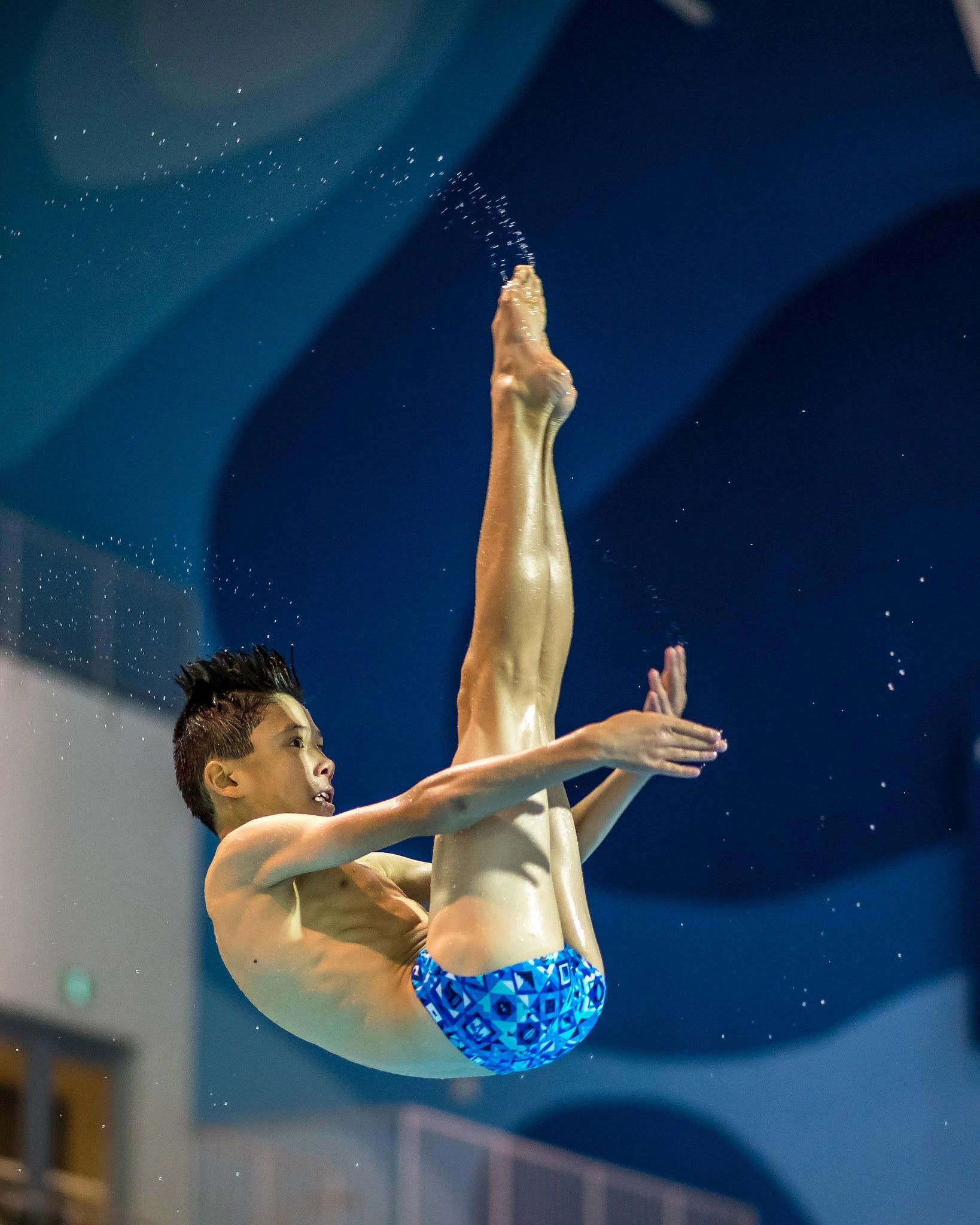 Diver spins through the air in pike position. 