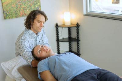 Dr. Leins examining a female patient on her back.