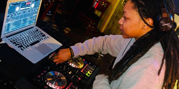 Female DJ mixing music with headphones.