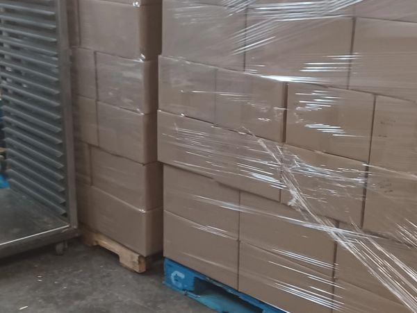 Stacked cardboard boxes wrapped in plastic on pallets.