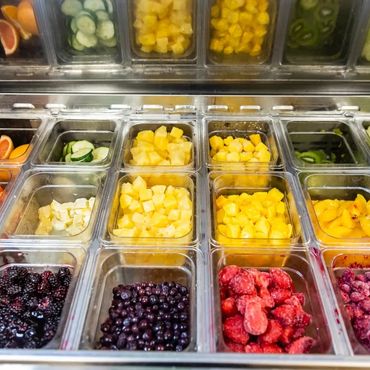 Freshly diced mango, pineapple, blueberries, and kiwi in smoothie prep bar. Paradise Smoothie