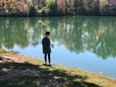 Young angler casting a fishing line into the lake at Edwardsville Gun Club during a sunny afternoon