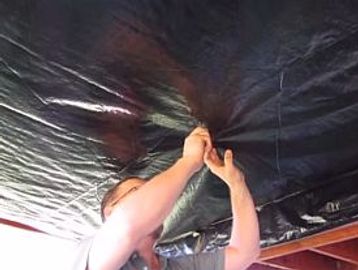 Contractor installing a vapor barrier for storm restoration by ICAS Storm Restoration FL.