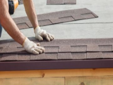 Roofing contractor installing shingles for roof services by ICAS Storm Restoration FL.