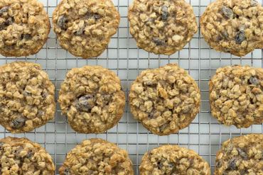 Freshly baked oatmeal raisin cookies cooling on a wire rack.