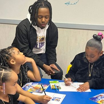 Adult supervising children drawing at a table.