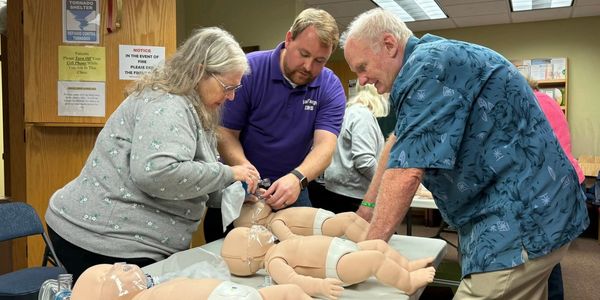 Board members, Deb and Tom Gilbertson perform training on infant models.