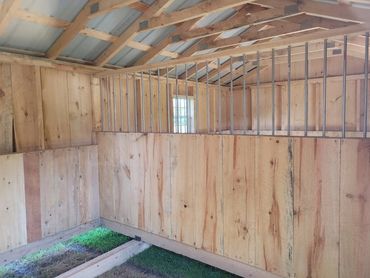 4' Kickwall with Metal Bar Divider inside of a Horse Barn