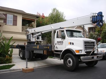 A Parks Crane Service truck is parked in a residential driveway