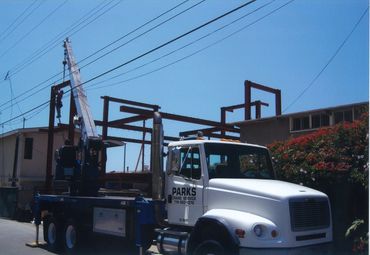 A crane truck is set up near a building