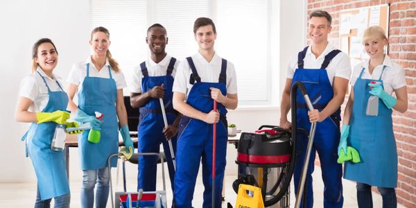 Group of professional cleaners in blue aprons.