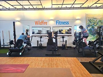 Two people working out in a gym named Wildfire Fitness.