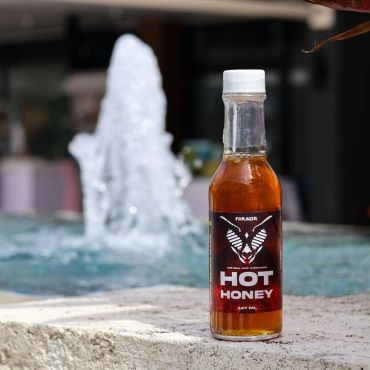 Bottle of Hipoint Farm hot honey by the poolside in Barbados.