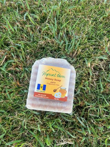 A bar of Hipoint Farm Honey Soap on grass.