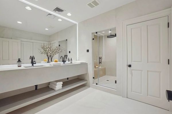 Modern bathroom with white fixtures and a large mirror.
