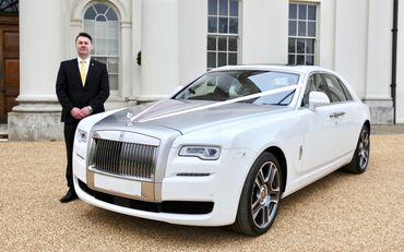 chauffeur standing next to a Rolls royce wedding car