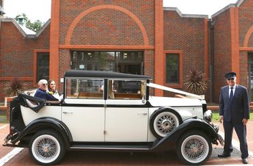 bride + groom in vintage car, chauffeur standing next to them
