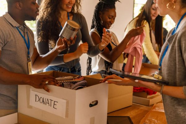 Hands placing a donation in a wooden box