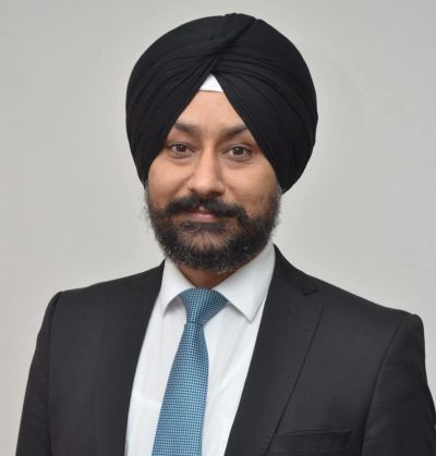 Professional man wearing a black turban and suit with a blue tie.