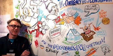 Artist poses with a finished graphic recording illustration of a speech.