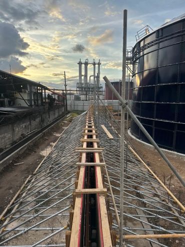 Construction site with metal framework and industrial tanks.