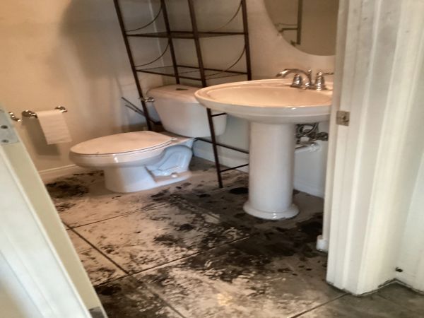 Bathroom after a fire resulting in fire damaged debris, smoke, and soot.